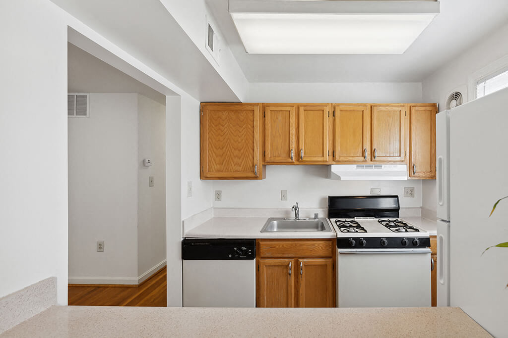 A bright kitchen with wooden cabinets at the Patrick Henry Apartments in Arlington, Virginia.